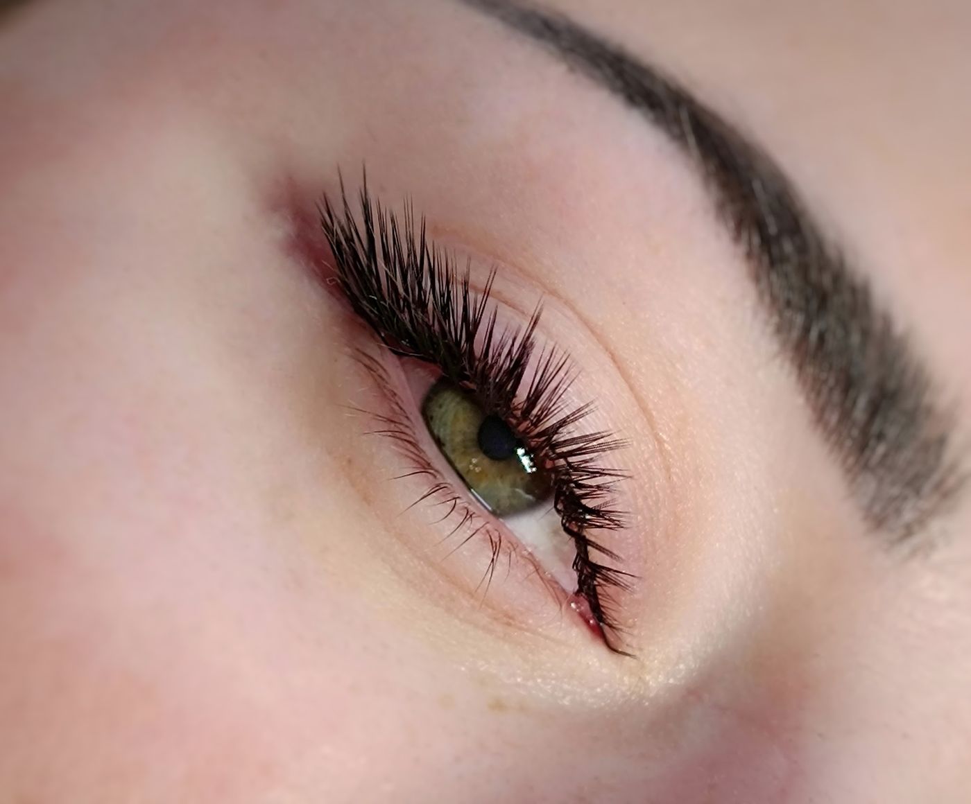 Een lichte, natuurlijke set wimperextensions bij een groen oog